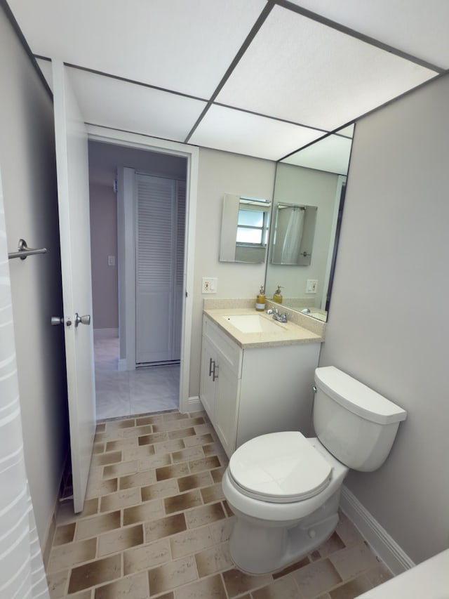 bathroom featuring baseboards, toilet, and vanity