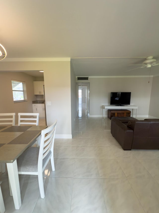 dining area featuring visible vents, ceiling fan, baseboards, ornamental molding, and light tile patterned flooring