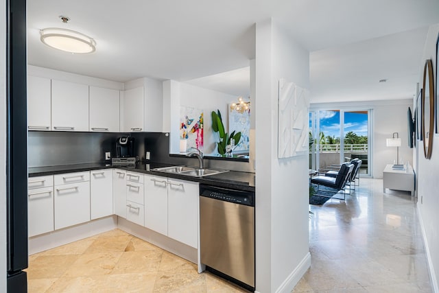 kitchen featuring a sink, stainless steel dishwasher, dark countertops, and white cabinetry