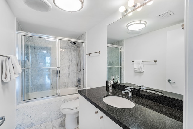 bathroom with vanity, toilet, visible vents, and bath / shower combo with glass door