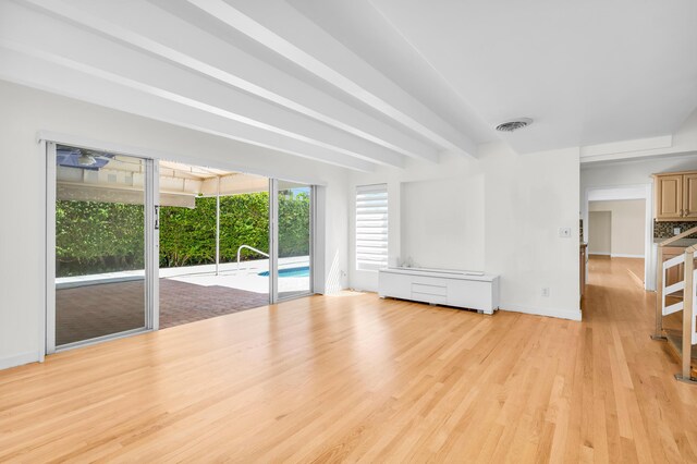 2601 NE 37th St, Fort Lauderdale, FL 33306 - unfurnished living room with light wood finished floors, baseboards, and beamed ceiling