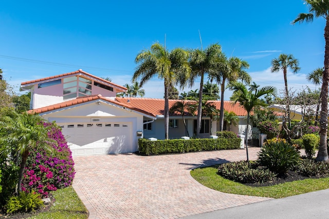 2601 NE 37th St, Fort Lauderdale, FL 33306 - view of front of home featuring an attached garage, driveway, a tile roof, and stucco siding