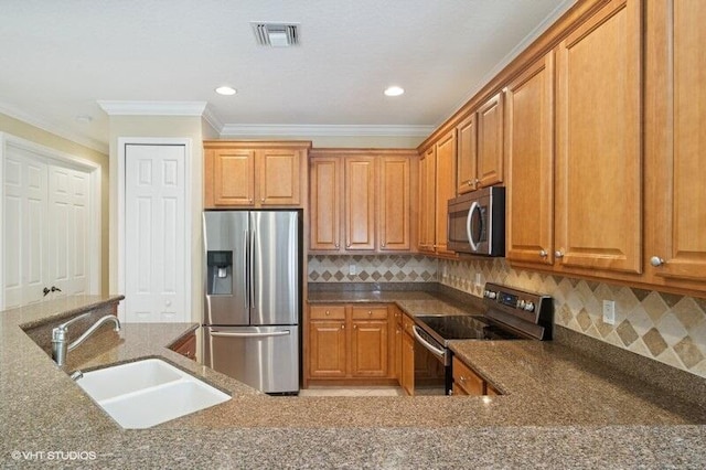 kitchen featuring a sink, visible vents, appliances with stainless steel finishes, and dark stone countertops