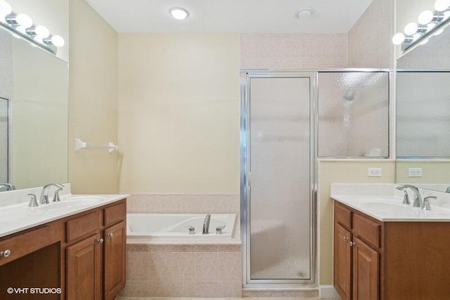 full bath featuring two vanities, a shower stall, a bath, and a sink