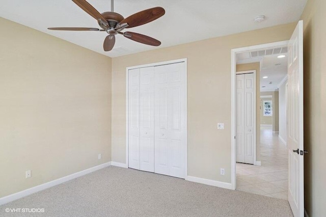 unfurnished bedroom with a ceiling fan, baseboards, visible vents, a closet, and light carpet