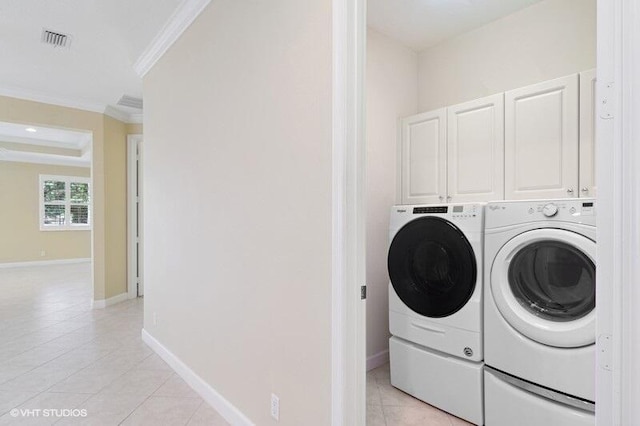 clothes washing area with visible vents, crown molding, light tile patterned floors, cabinet space, and separate washer and dryer