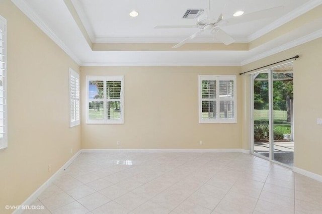 empty room with a tray ceiling, visible vents, and a healthy amount of sunlight