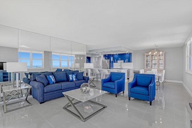 living area with a notable chandelier, baseboards, and light tile patterned floors