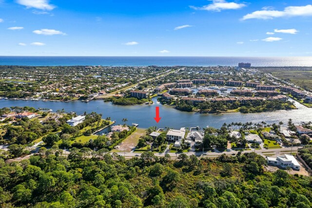 aerial view with a water view and a wooded view