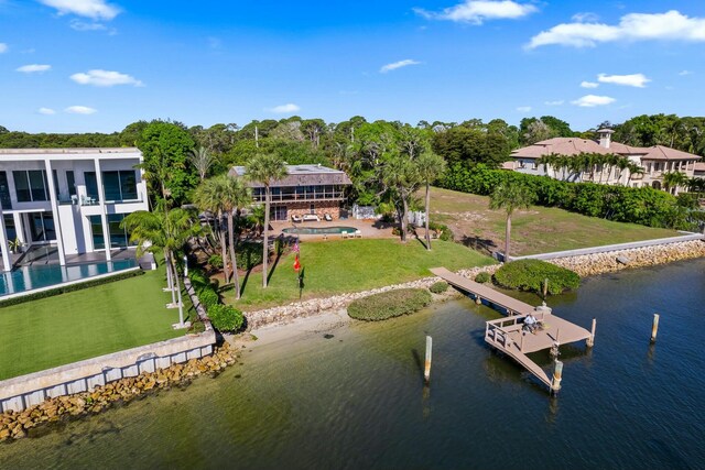 dock area with a yard, a water view, and boat lift