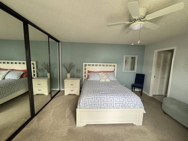 carpeted bedroom with a textured ceiling and a ceiling fan