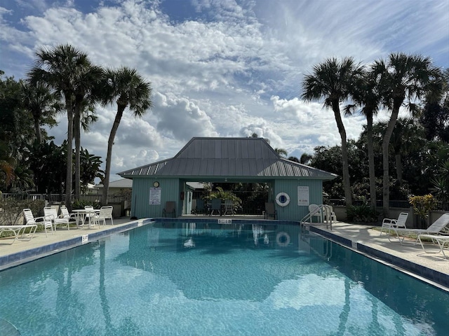 pool with a patio and fence