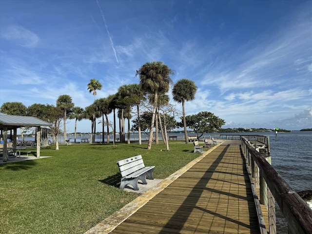 view of dock featuring a lawn and a water view