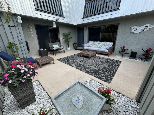 view of patio with outdoor lounge area and a balcony