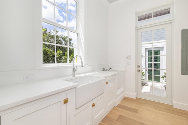 205 Gray St, West Palm Beach, FL 33405 - kitchen featuring light wood-style flooring, white cabinetry, light countertops, and electric panel