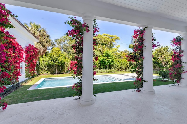 pool with a patio and a lawn