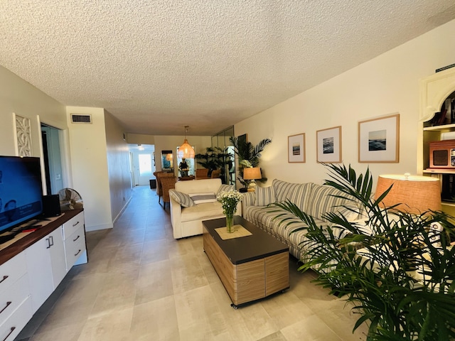 living area with visible vents and a textured ceiling