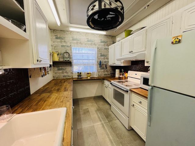 kitchen with white appliances, a sink, decorative backsplash, butcher block countertops, and under cabinet range hood