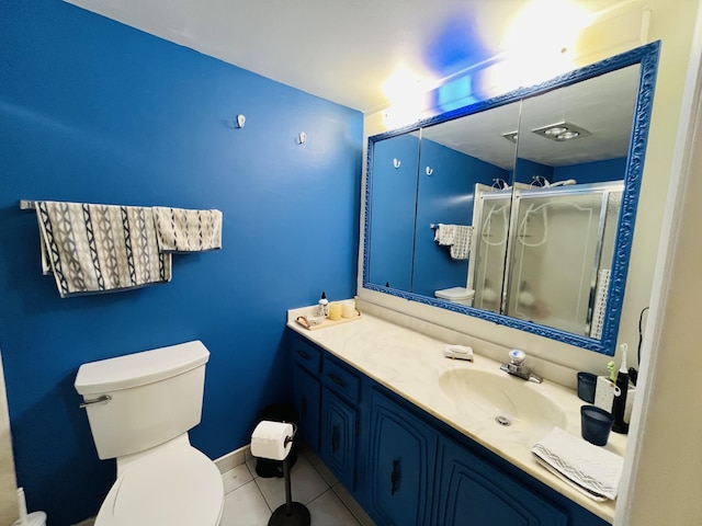 full bathroom featuring vanity, baseboards, a stall shower, tile patterned floors, and toilet