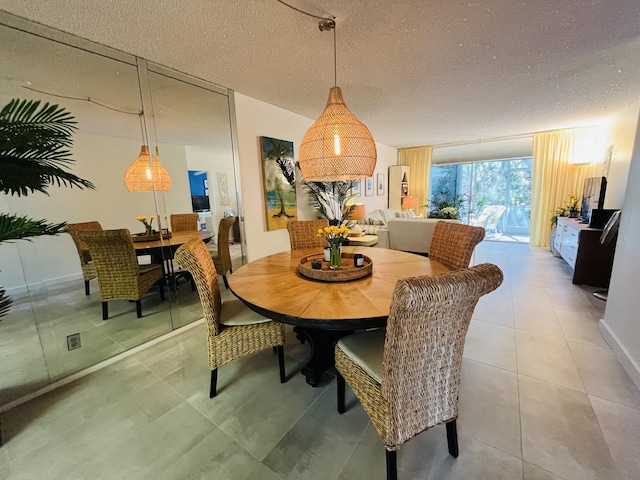 tiled dining space featuring a textured ceiling and expansive windows