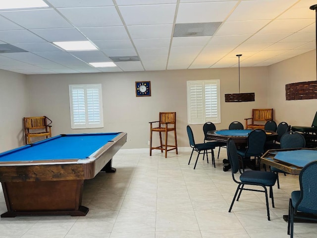 game room with light tile patterned floors, a paneled ceiling, and baseboards