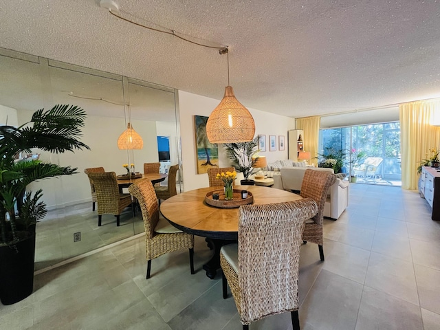 dining room featuring tile patterned floors, a textured ceiling, and a wall of windows