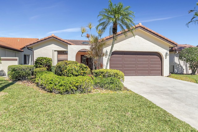 mediterranean / spanish house featuring stucco siding, driveway, a tile roof, and a garage