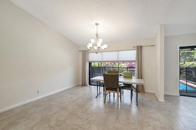 dining area featuring a textured ceiling, baseboards, and a chandelier