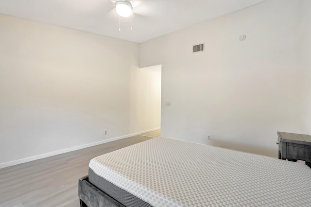 bedroom featuring visible vents, baseboards, a ceiling fan, and wood finished floors