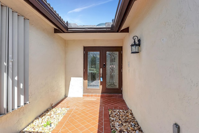 property entrance featuring stucco siding and french doors