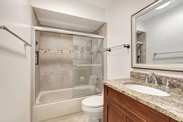 bathroom with vanity, toilet, and bath / shower combo with glass door