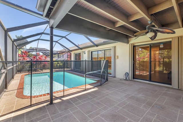 pool with glass enclosure, a patio, and ceiling fan