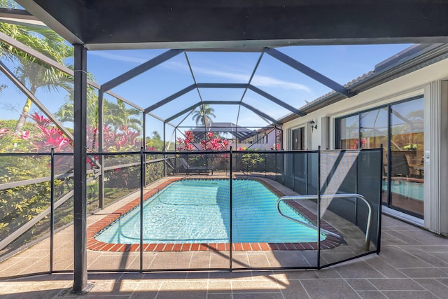 view of pool with glass enclosure, a patio area, and a fenced in pool