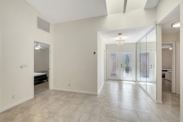 foyer featuring ceiling fan with notable chandelier, french doors, visible vents, and baseboards