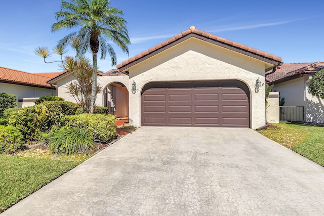 mediterranean / spanish house featuring stucco siding, concrete driveway, and an attached garage