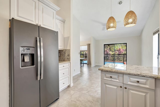 kitchen featuring backsplash, light stone countertops, stainless steel fridge with ice dispenser, hanging light fixtures, and white cabinets