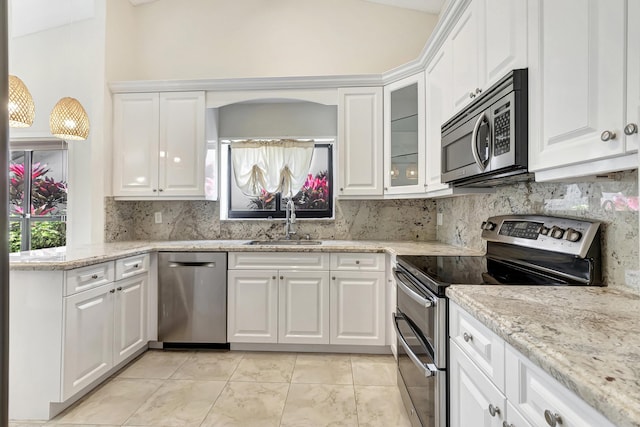 kitchen featuring a sink, stainless steel appliances, backsplash, and white cabinetry