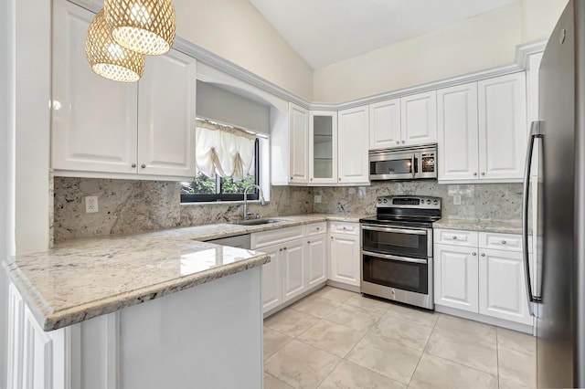 kitchen featuring a sink, a peninsula, appliances with stainless steel finishes, white cabinets, and decorative backsplash