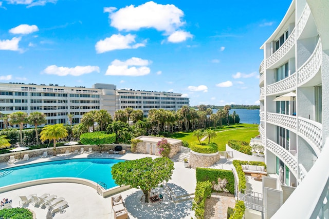 community pool with a patio and a water view