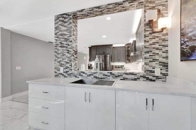 kitchen featuring baseboards, stainless steel fridge with ice dispenser, a sink, marble finish floor, and tasteful backsplash