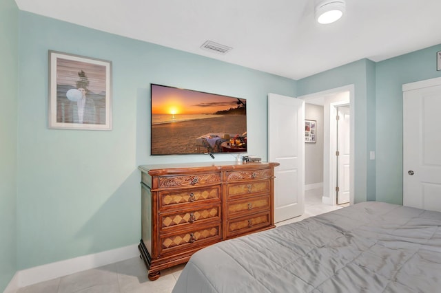 bedroom featuring light tile patterned floors, visible vents, and baseboards