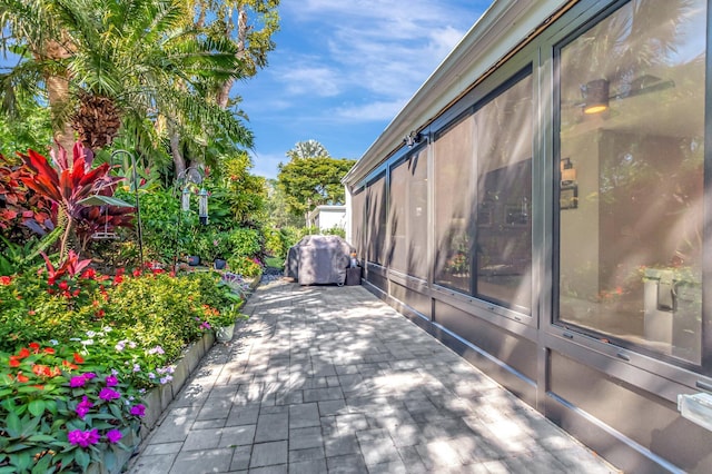 view of side of property featuring a patio and a sunroom