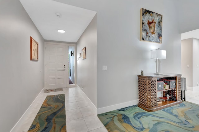 foyer entrance with light tile patterned floors and baseboards