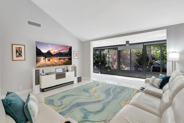 living room featuring tile patterned floors, visible vents, a wealth of natural light, and high vaulted ceiling