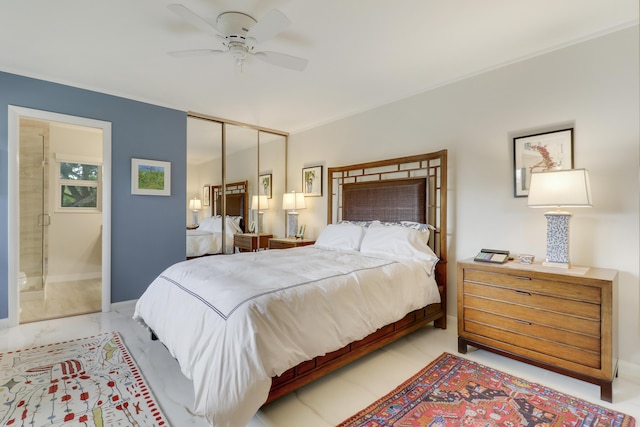 bedroom with ensuite bath, a ceiling fan, a closet, and baseboards