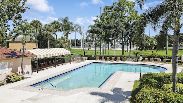 pool featuring a yard, a patio, and fence
