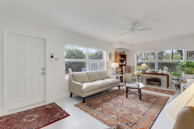 living room featuring a healthy amount of sunlight, baseboards, and ceiling fan