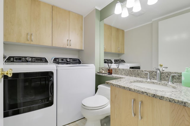 washroom with laundry area, crown molding, independent washer and dryer, and a sink