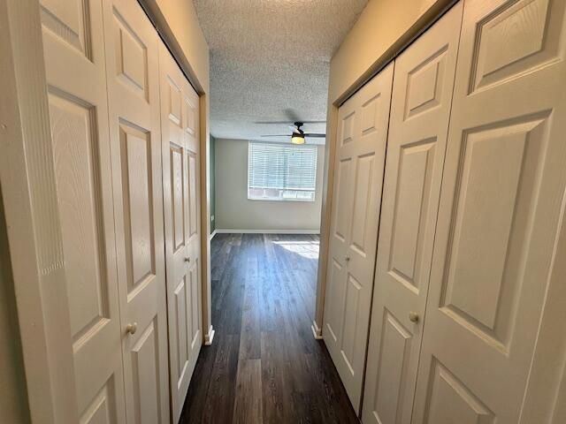 7896 Sonoma Springs Cir Unit 204, Lake Worth, FL 33463 - corridor featuring a textured ceiling, dark wood-type flooring, and baseboards
