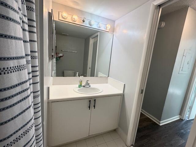 7896 Sonoma Springs Cir Unit 204, Lake Worth, FL 33463 - full bathroom featuring toilet, vanity, a shower with shower curtain, and baseboards